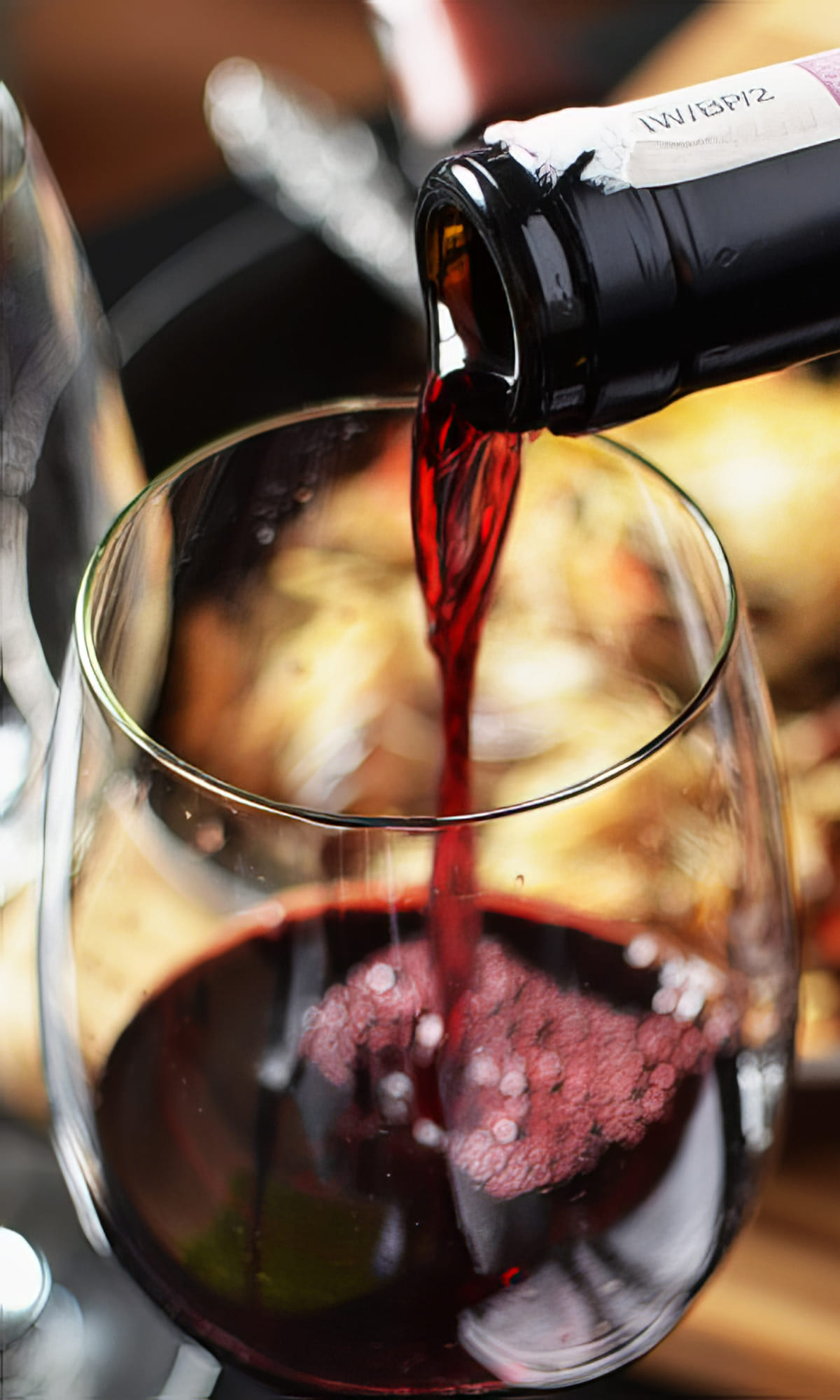 Vino tinto siendo servido en una copa, el complemento perfecto para las comidas de Las delicias del monasterio en Madrid.